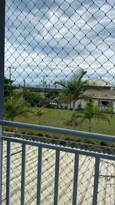 a fence with a view of a park with palm trees at Casa praia da Gamboa garopaba in Garopaba