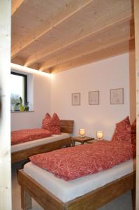 two beds in a room with wooden ceilings at Ferienwohnung, 1-Zimmer, 1-3 Personen, 31 qm, mit Balkon, in ruhige Lage, direkt an der Aach in Singen