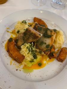 un plato de comida con brócoli y patatas en una mesa en Ferienwohnung mit Kamin und traumhafter Dachterrasse mit Weitblick in die Natur, en Neu Gaarz