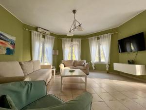ein Wohnzimmer mit einem Sofa und einem Tisch in der Unterkunft Villa Platanias in Agia Paraskevi