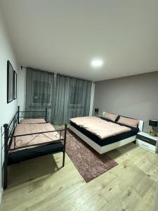 twee bedden in een kamer met houten vloeren bij Luxury Apartment Ottweiler in Ottweiler