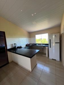 eine Küche mit einem weißen Kühlschrank und einer Arbeitsplatte in der Unterkunft Casa do alto pipa in Pipa