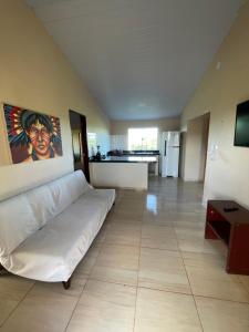 ein großes Wohnzimmer mit einer weißen Couch und einer Küche in der Unterkunft Casa do alto pipa in Pipa