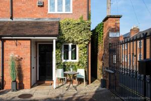 a patio with a table and chairs in front of a building at 4 Bed Townhouse 2 mins from everything & 1 parking space! in Stratford-upon-Avon