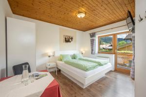 1 dormitorio con cama, mesa y ventana en Landhaus Aubauerngut, en Radstadt