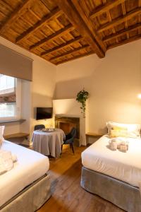 a hotel room with two beds and a table at Fontana di Trevi Roma Luxury Suite in Rome