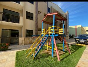 a playground with a slide in front of a building at Flat Crystal Park Porto das Dunas- Cristal park in Aquiraz