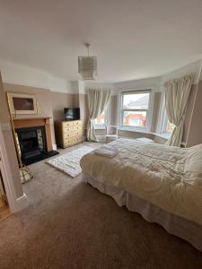 a large bedroom with a bed and a fireplace at Liberty House in Southampton