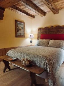 Un dormitorio con una cama grande y una mesa con un tazón. en B&B Lo Djoua de Toueno, en Arvier