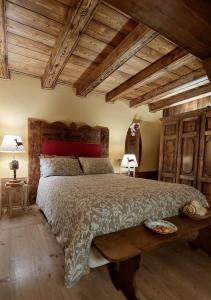 1 dormitorio con 1 cama grande y techo de madera en B&B Lo Djoua de Toueno, en Arvier