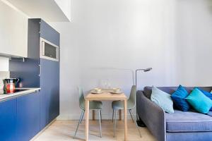 a living room with a blue couch and a table at Saint Jean Baptiste, studio pour 2 personnes Garibaldi, Coulée Verte in Nice