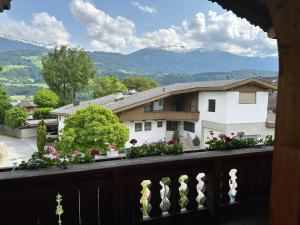 balcón con vistas a una casa y a las montañas en Ferienwohnung Volgger en Mils bei Hall