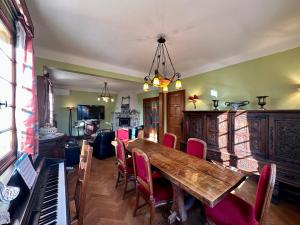 a dining room with a table and chairs and a piano at Chambre d'hôte a Yenne avec télé in Yenne