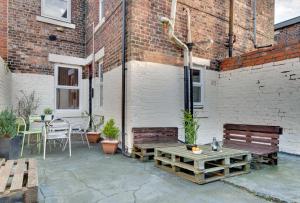 a patio with two benches and a table at Newcastle CITY Apartments 35 in Newcastle upon Tyne