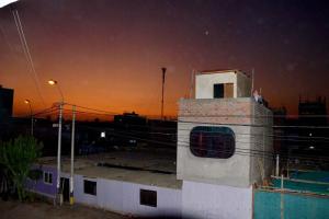 un edificio con una torre encima por la noche en HOSPEDAJE LINDA LIRIO, en Paracas