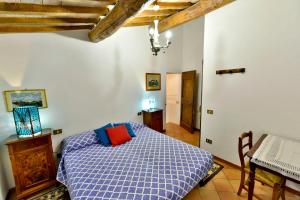 a bedroom with a blue bed with a red pillow at Agriturismo Corvaia in Radicofani