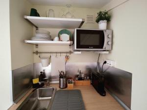 una cucina con lavandino e una TV a parete di Vilas do Mar - Studio a Carvoeiro