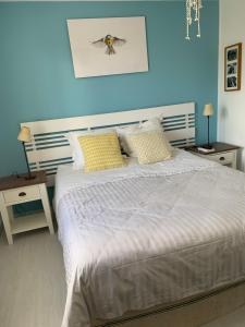 een slaapkamer met een bed en een blauwe muur bij Appartement supérieur sur l 'étang in Sète