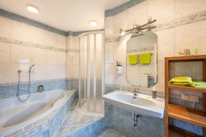 een badkamer met een bad en een wastafel bij Landhaus Aubauerngut in Radstadt