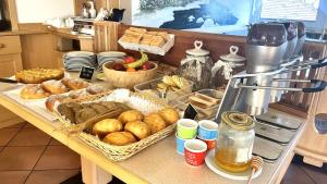 Garnì Belvedere في بريدازو: طاولة بها العديد من الأنواع المختلفة من الخبز والمعجنات