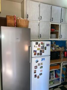 a kitchen with a refrigerator with magnets and cabinets at Chambre privée dans Maison Familiale in Veyrier-du-Lac