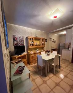 una cucina e una sala da pranzo con tavolo e sedie di Casa in centro Randazzo a Randazzo