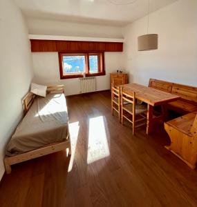 a room with a table and a bed and a desk at Brown bear home in Roccaraso