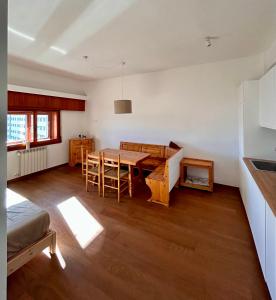 a living room with a wooden table and a kitchen at Brown bear home in Roccaraso