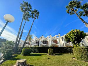 una gran casa blanca con palmeras delante en Contemporary House in Cabo Roig, en Playas de Orihuela