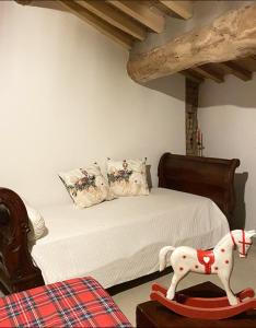 Il Corvo Viaggiatore في Solarolo Monasterolo: غرفة نوم بسرير مع فرس لعبة على طاولة