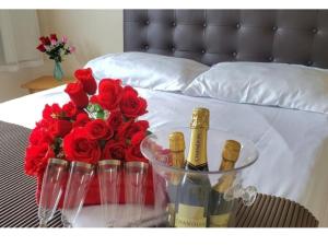 a table with two bottles of champagne and red roses at EcoCasa Rio Sauípe 200 m da Praia in Porto de Sauipe