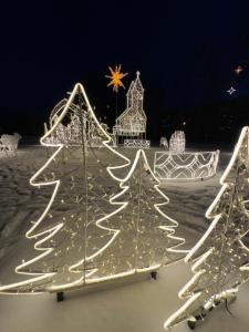 una exposición de árboles de Navidad iluminados en la nieve en Cozy Studio Charming Spot Piņķi, en Piņķi