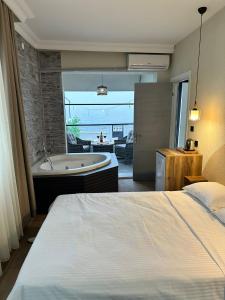 a hotel room with a bed and a bath tub at Kingway Suite in Nusratlı