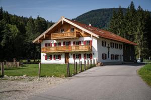 a large white building with a wooden roof at Hochwertige Ferienwohnung Hochsitz in Saulgrub