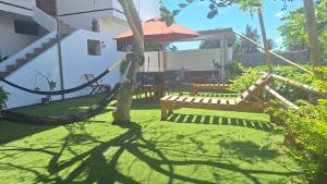 a garden with a hammock and a bench in a yard at Galápagos Brunette Suites I in Puerto Ayora