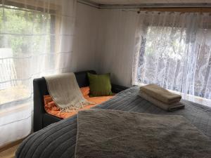 a bedroom with a bed and a couch and a window at Fran&EmmaIII in Temuco
