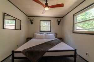 a bedroom with a bed with a ceiling fan at Mud Creek Cottage in Cheboygan
