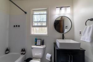 a white bathroom with a sink and a mirror at Mud Creek Cottage in Cheboygan +62 photos