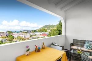 La Créola New! Grand Case - vue mer - appart 4p - King size في غراند كيس: غرفة طعام مع طاولة صفراء ونافذة كبيرة