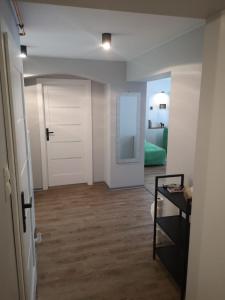 einen Flur mit einer Tür und ein Zimmer mit einem Tisch in der Unterkunft Apartament Dominik in Głuszyca