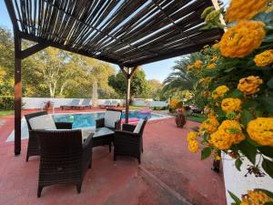 un patio con tavolo, sedie e piscina di Villa Platanias ad Agia Paraskevi