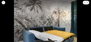 a bedroom with a blue bed with a palm tree mural at La Créola New! Grand Case - vue mer - appart 4p - King size in Grand Case