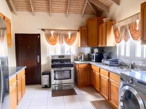 cocina con armarios de madera y horno con fogones en Casa Amarilla en Woods