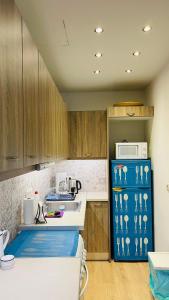 a kitchen with a sink and a blue refrigerator at Cozy apartment ideally located city center and Megaron Moussikis metro station in Athens