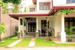 a house with a porch with a chair in the yard at Seasons Villa in Dambulla