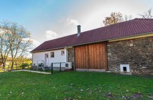 dom z drewnianymi drzwiami i trawnikiem w obiekcie Ubytování na samotě - Apartmán U Tesařů w mieście Komařice