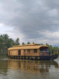 a house boat traveling down a river at SR Houseboats Kumarakom in Kumarakom