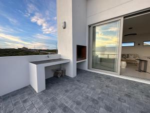 a balcony with a table and a view of the ocean at Atlantic Corner in Yzerfontein