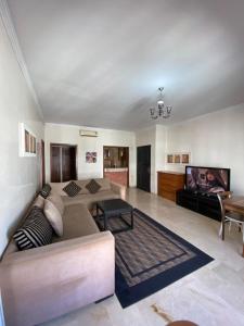 Il comprend un salon doté d'un canapé et d'une télévision à écran plat. dans l'établissement Résidence marina agadir, à Agadir