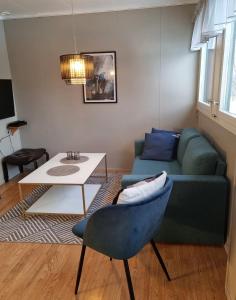 een woonkamer met een blauwe bank en een tafel bij Storgalten gjestehus in Nord-Lenangen